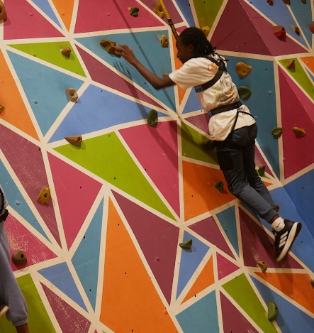 young person on colourful climbing wall
